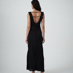 Woman wearing a black dress with ruffled straps on a white background