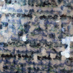 Close-up of a sequin fabric in blue, green, and beige.