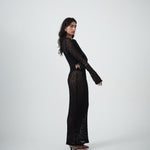 VARNA Cecil Maxi Dress styled in an editorial lookbook — sheer black lace dress with long sleeves and body-skimming silhouette.