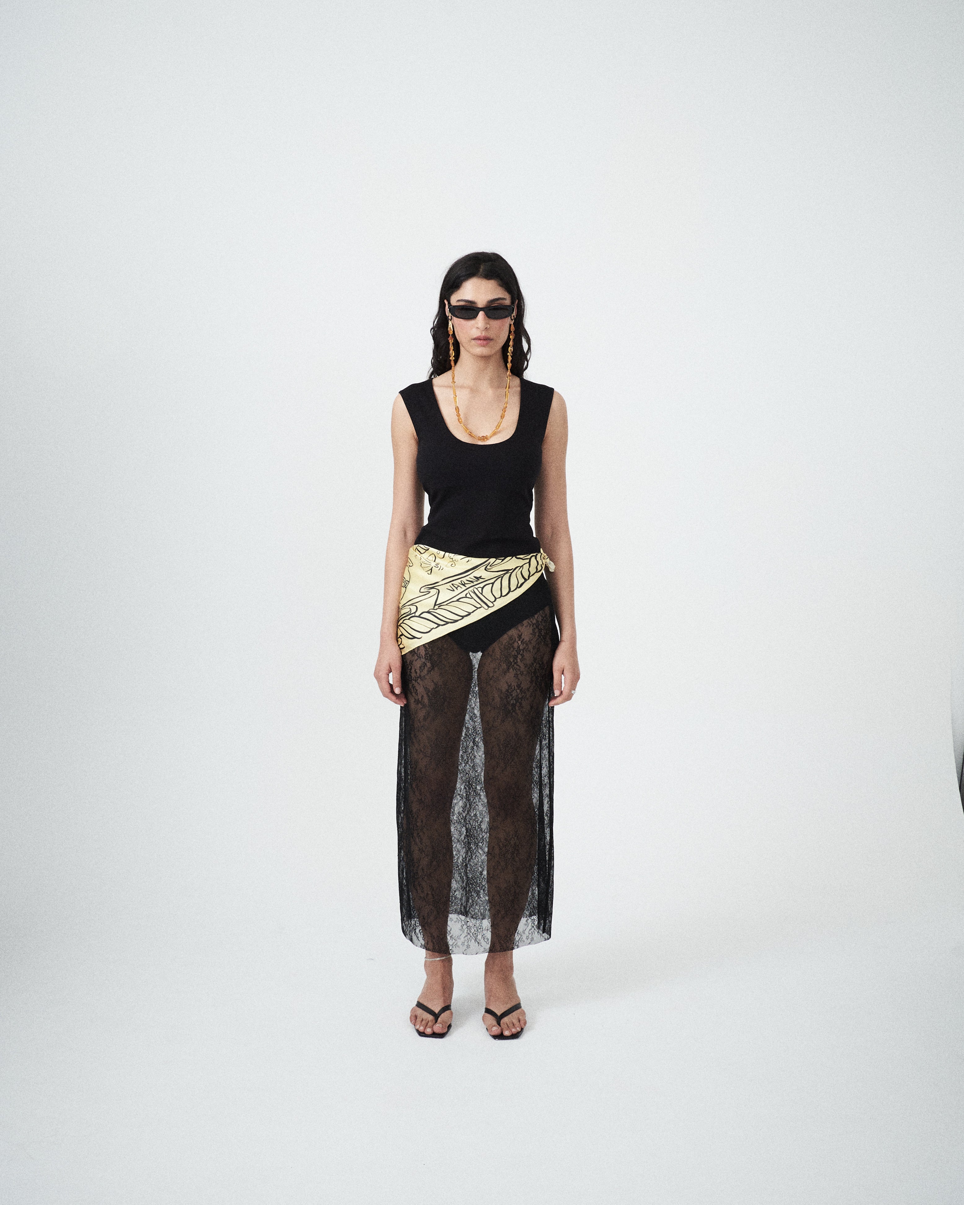 Editorial mood image of the VARNA Lucienne Maxi Lace Skirt in black — designer sheer floral lace skirt with straight silhouette and elegant drape.