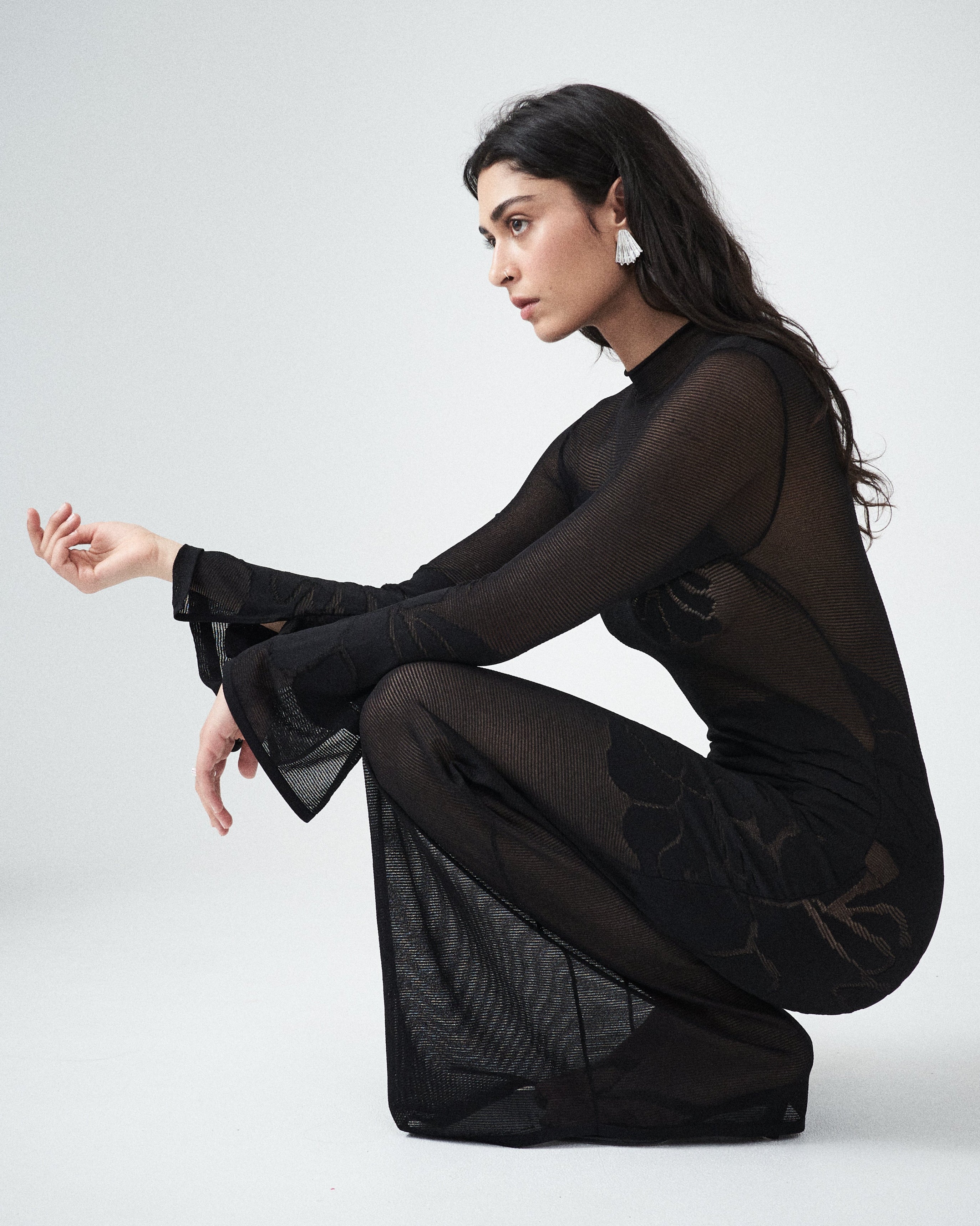 Editorial homepage image featuring the VARNA Seraphine Knit Maxi Dress in black — designer sheer knit with floral detailing and fluid silhouette.