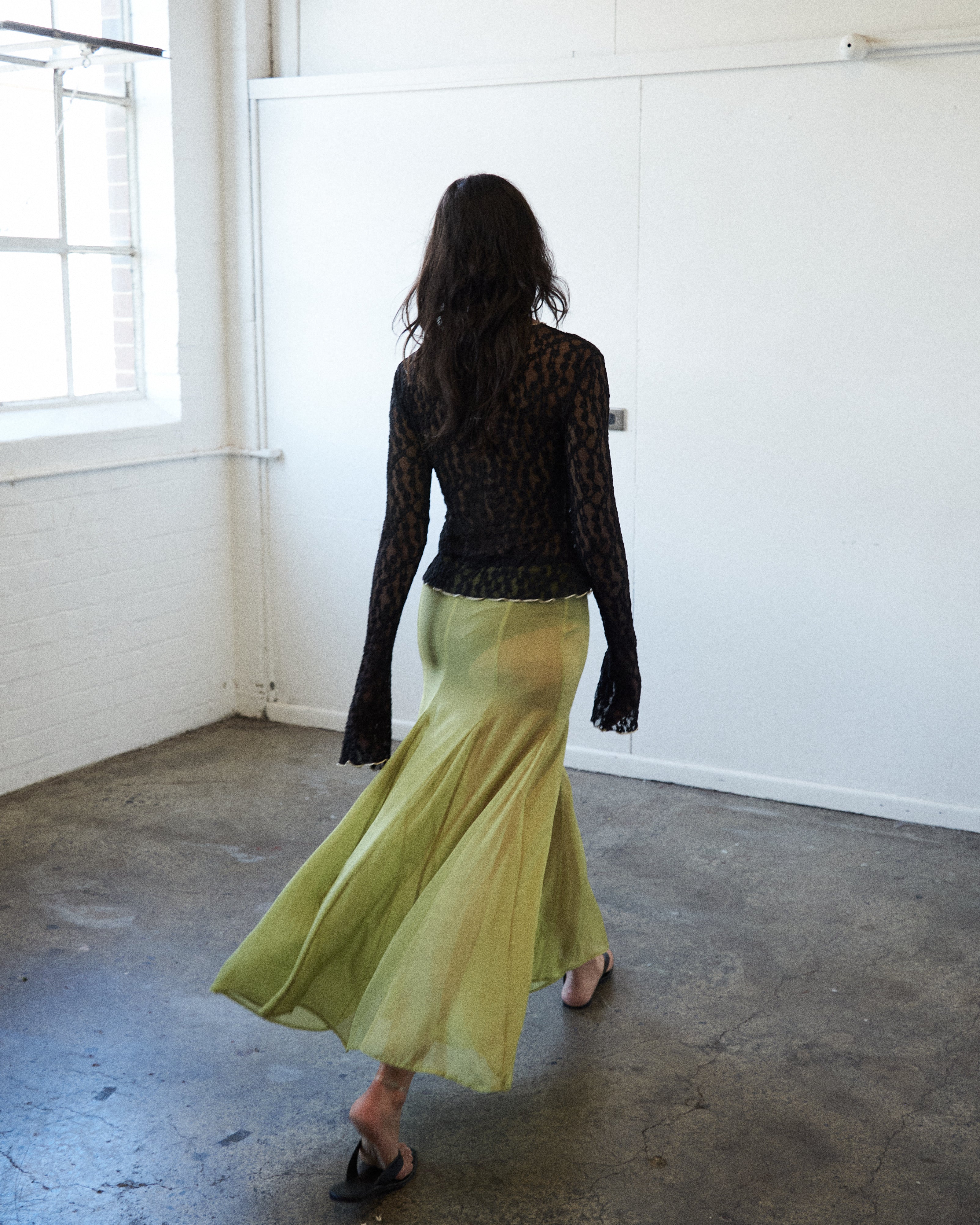 Back view of the VARNA Arden Full Maxi Skirt in pear silk showing high waist, soft drape, and flowing movement.