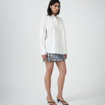 Three-quarter view of designer white cotton shirt by VARNA showing structured collar, relaxed silhouette, and soft drape.
