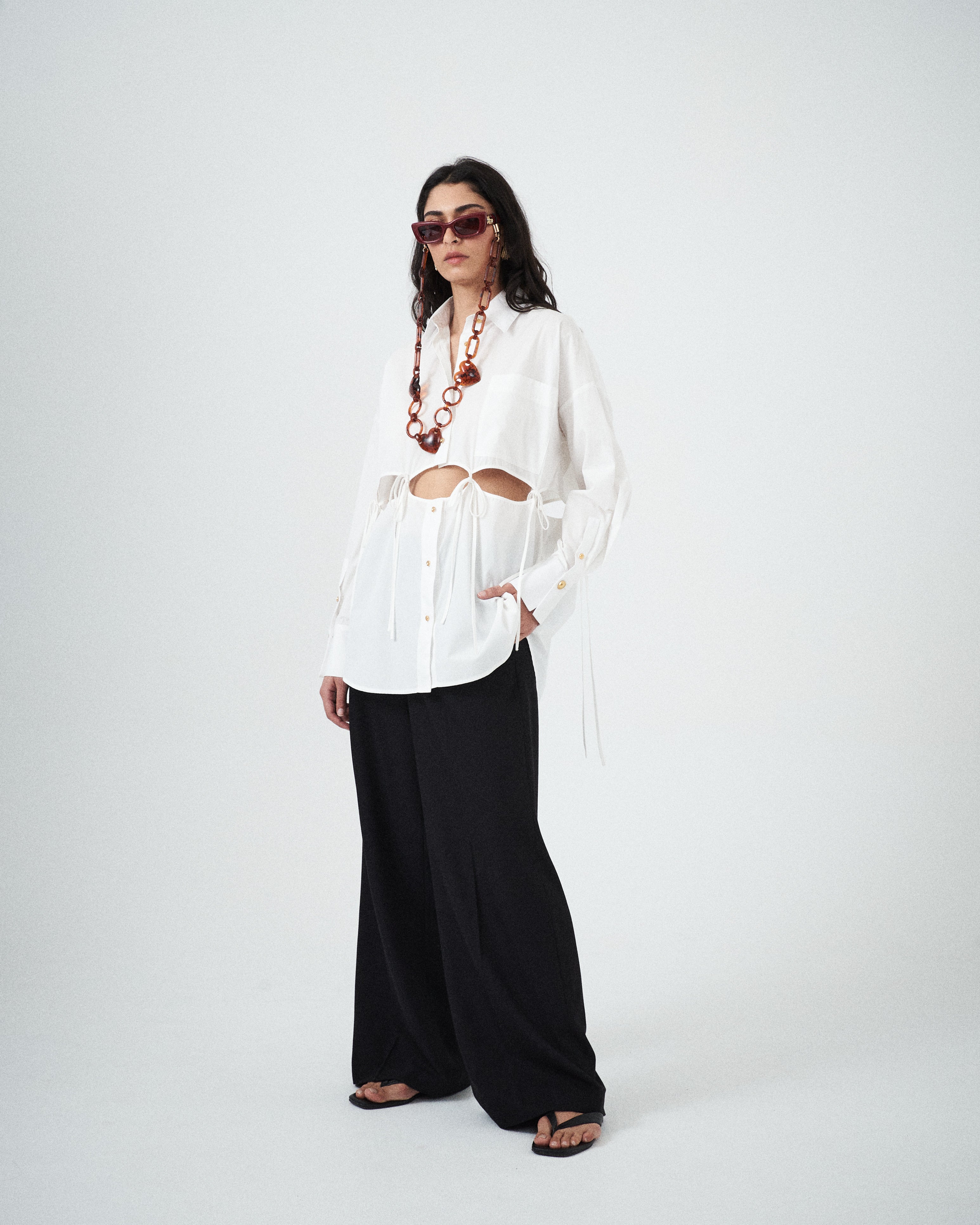 Designer white cotton shirt by VARNA with statement cut-outs and side ties.