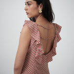 Close-up detail of neckline ruffles and check fabric texture 