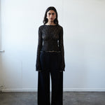 Designer black lace top by VARNA with scalloped hem and flared cuffs.