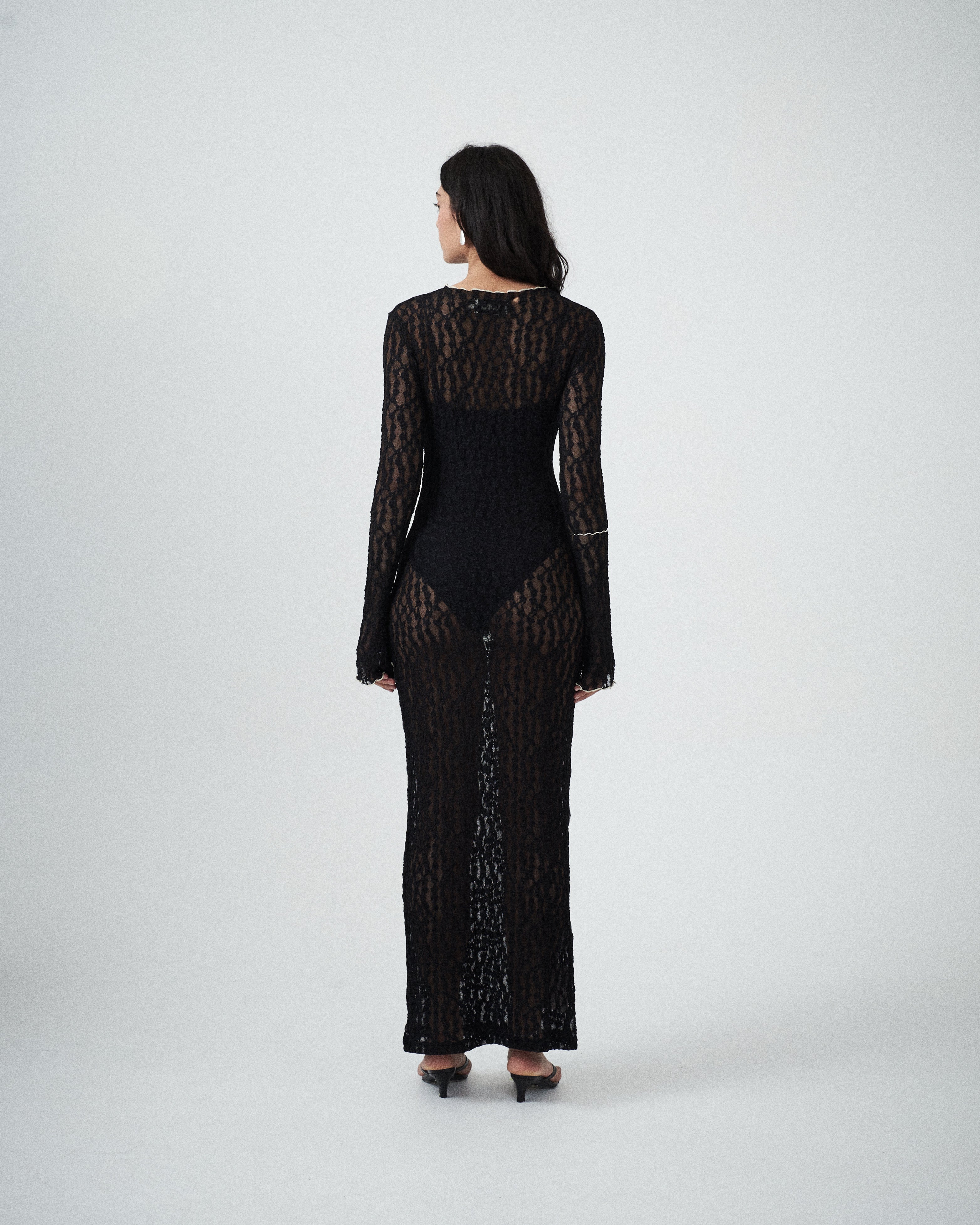 Back view of VARNA Cecil Maxi Dress in intricate black lace with slim silhouette and maxi length.