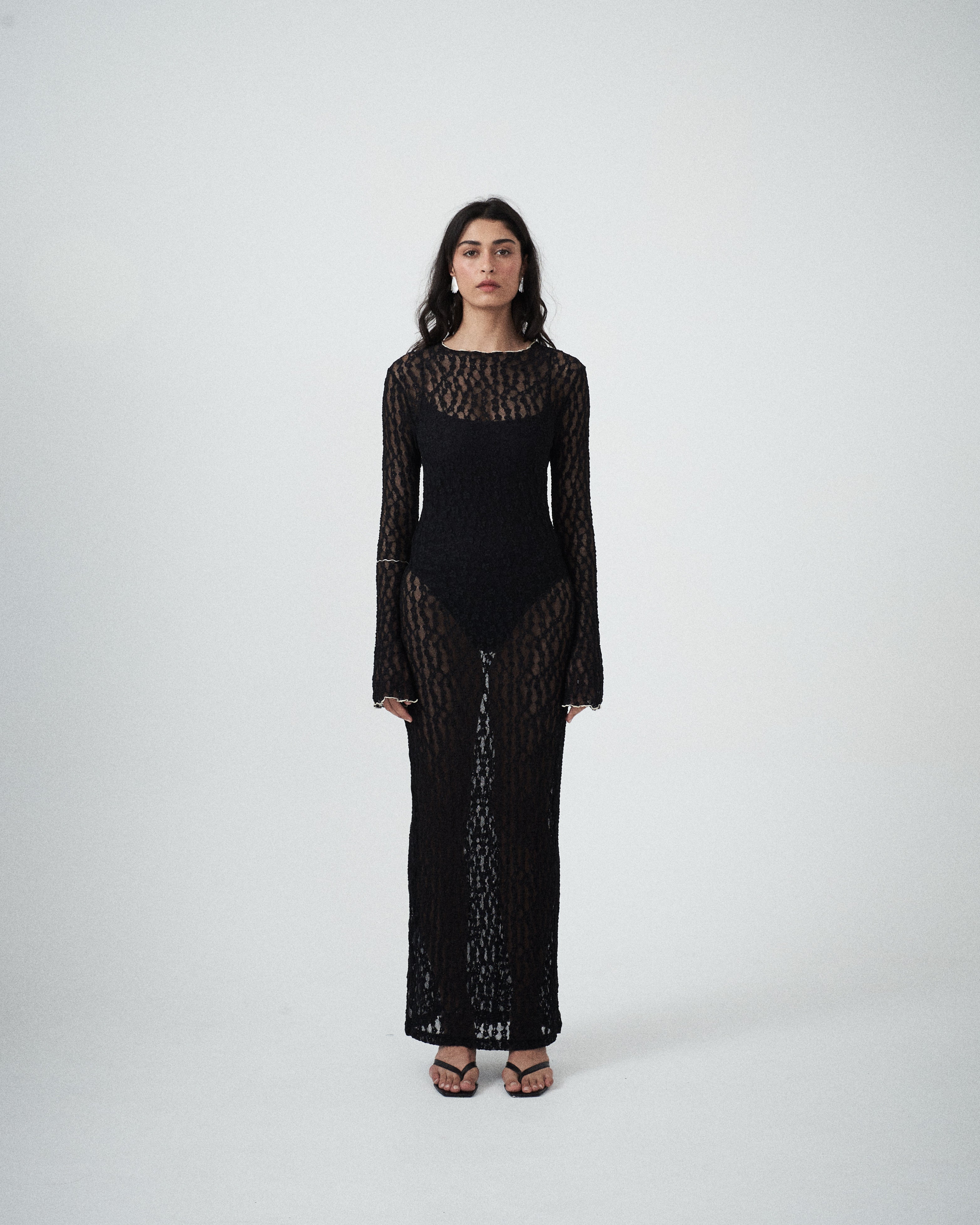 Front view of VARNA Cecil Maxi Dress in black floral lace with semi-sheer design and scalloped detailing.