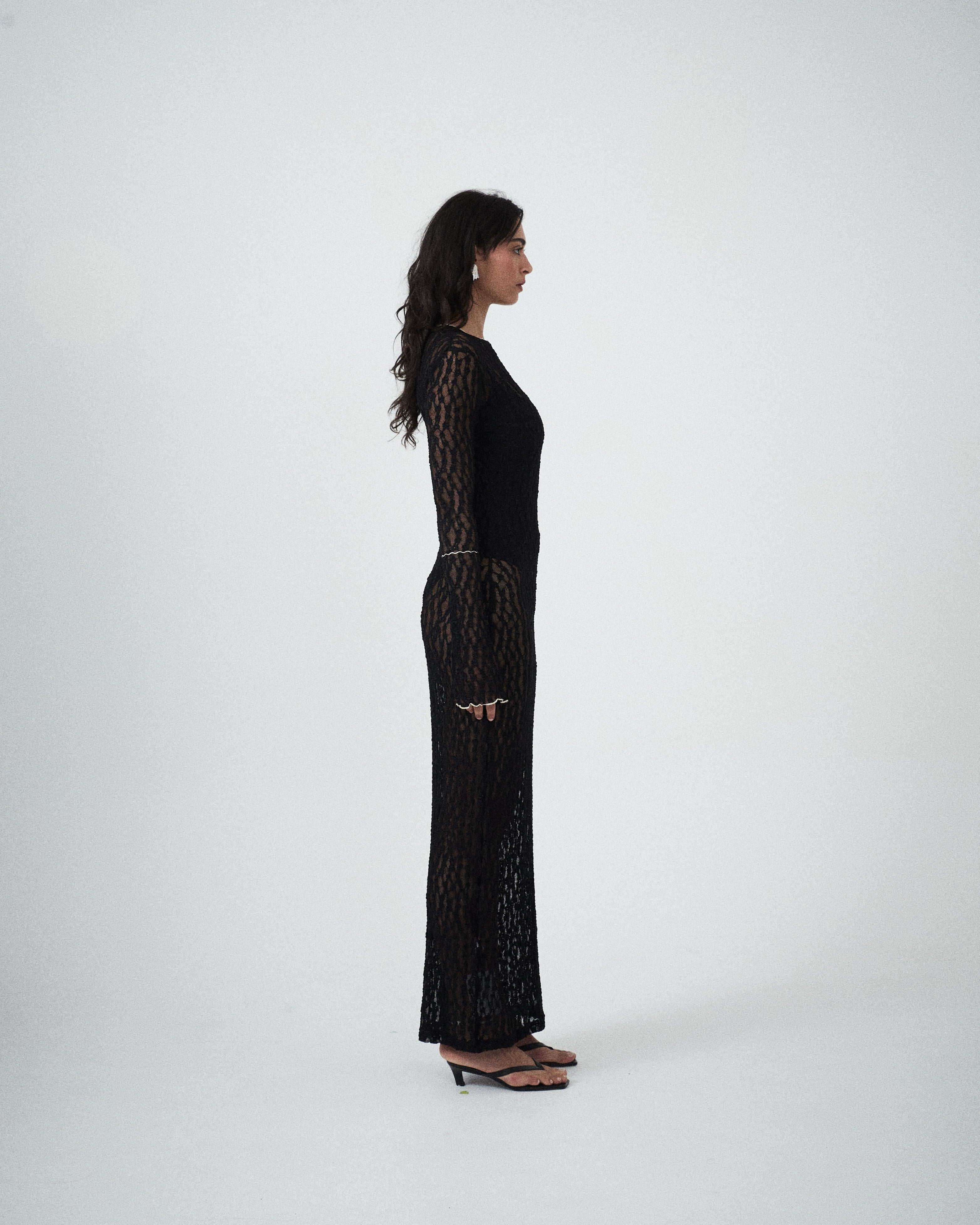 Side profile of VARNA Cecil Maxi Dress highlighting semi-sheer floral lace and elegant body-skimming fit.