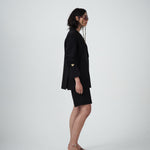 Side profile of VARNA Erica Oversized Blazer in black highlighting its fluid, oversized drape and clean tailored lines.