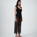 Side profile of VARNA Lucienne Maxi Lace Skirt in black — sheer floral lace fabric highlighting graceful drape and straight silhouette.
