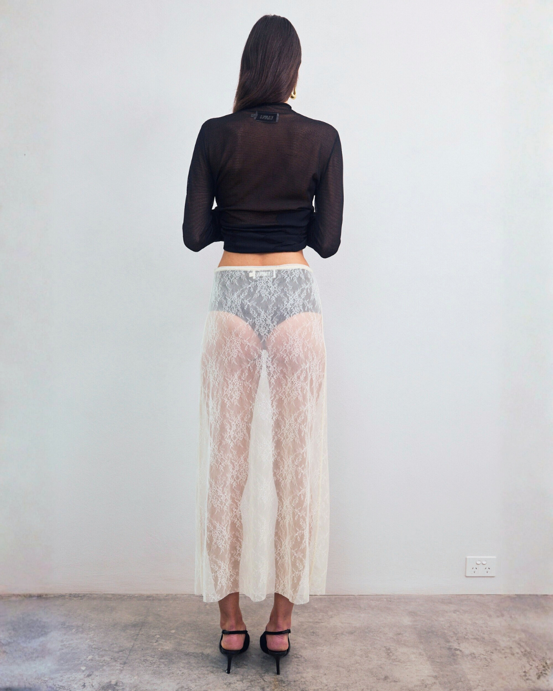 Back view of VARNA Lucienne Maxi Lace Skirt in milk floral lace highlighting sheer finish and fluid drape.