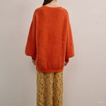 Back view of VARNA Lucienne Maxi Lace Skirt in tangerine lace highlighting elegant drape, scalloped hem, and delicate floral pattern.