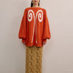 Front view of VARNA Lucienne Maxi Lace Skirt in tangerine floral lace showing scalloped hem, semi-sheer finish, and full-length cut.