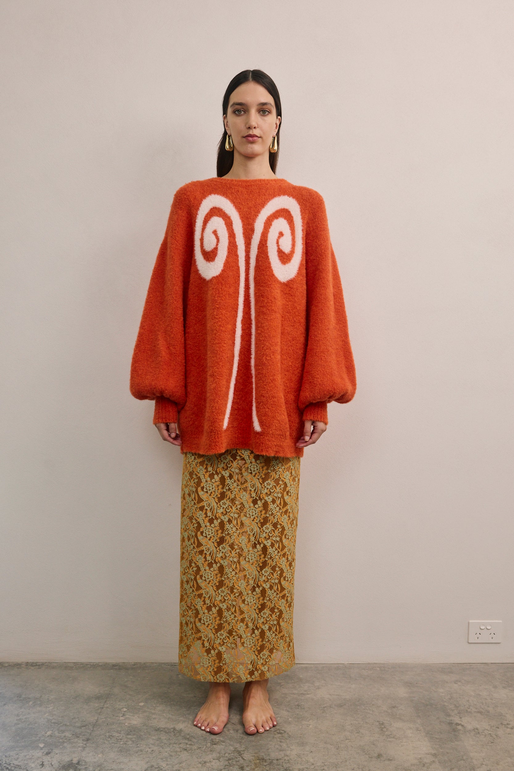 Front view of VARNA Lucienne Maxi Lace Skirt in tangerine floral lace showing scalloped hem, semi-sheer finish, and full-length cut.