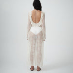 Back view of VARNA Lucienne Ruffle Lace Maxi Dress in milk featuring open low back with tie and soft ruffled hem.