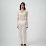 Front view of VARNA Lucienne Ruffle Lace Maxi Dress in milk styled with bra and briefs — sheer lace texture and fluted sleeves.