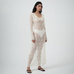 Three-quarter view of VARNA Lucienne Ruffle Lace Maxi Dress in milk showing low back tie, ruffled hem, and soft drape