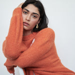 VARNA Maris Knit Top in tangerine alpaca-wool blend styled in a relaxed mood setting — oversized fit with statement sleeves.