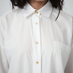 Detail view of VARNA Rhea Shirt showing crisp white cotton texture and front button placket.