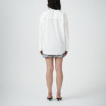 Back view of VARNA Rhea Shirt in crisp white cotton with subtle drop shoulders and gold-tone buttons.
