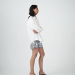 Side profile of VARNA Rhea Shirt highlighting relaxed tailoring, drop shoulders, and pleated cuff detail.