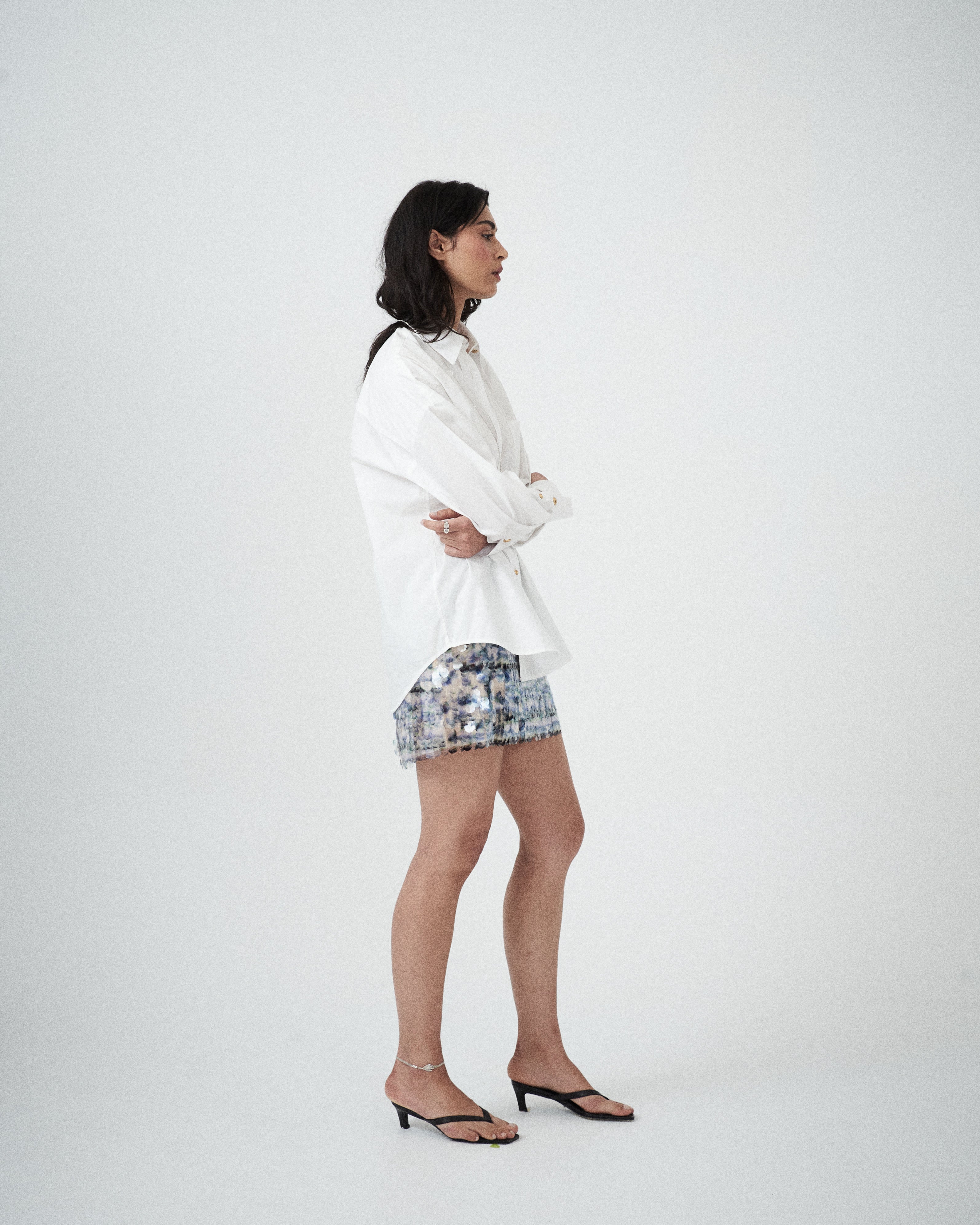 Side profile of VARNA Rhea Shirt highlighting relaxed tailoring, drop shoulders, and pleated cuff detail.