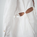 Crisp white cotton fabric of VARNA Rhea Tied Shirt with gold-tone buttons and tie details.