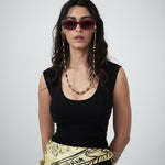 Model styling black jersey tank with sunglasses and chain