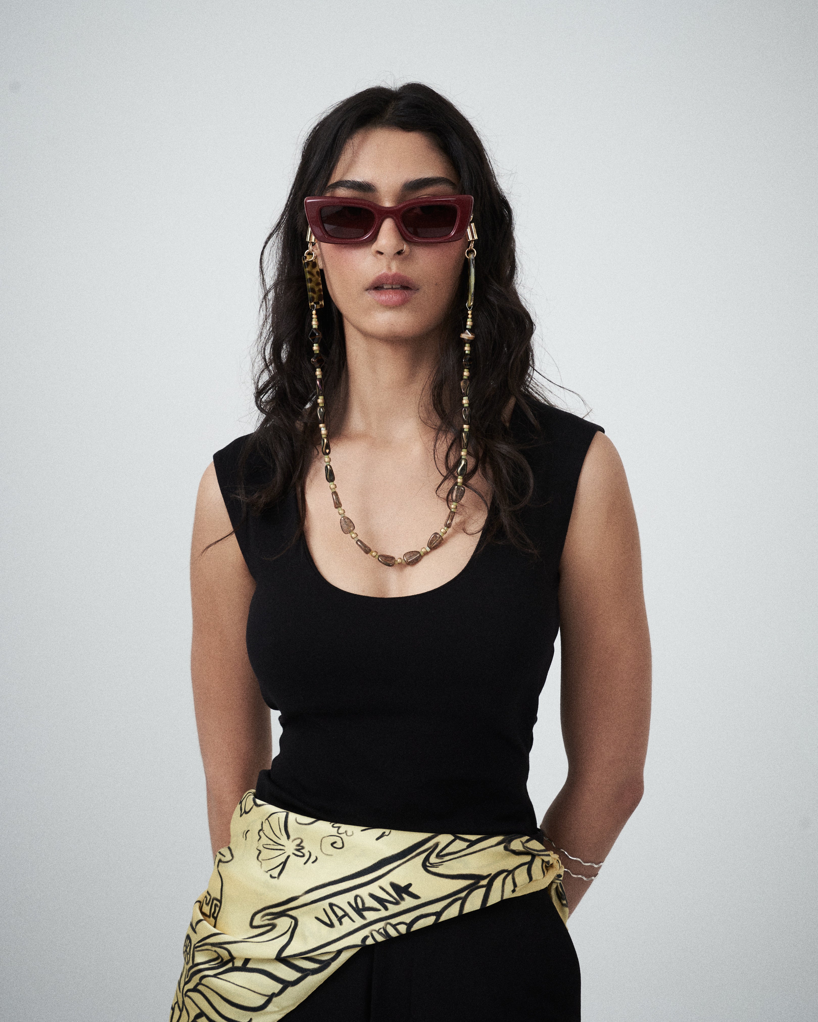 Model styling black jersey tank with sunglasses and chain