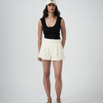 VARNA Valencia Soft Cap styled on model — a cream drill designer cap with embroidered logo.