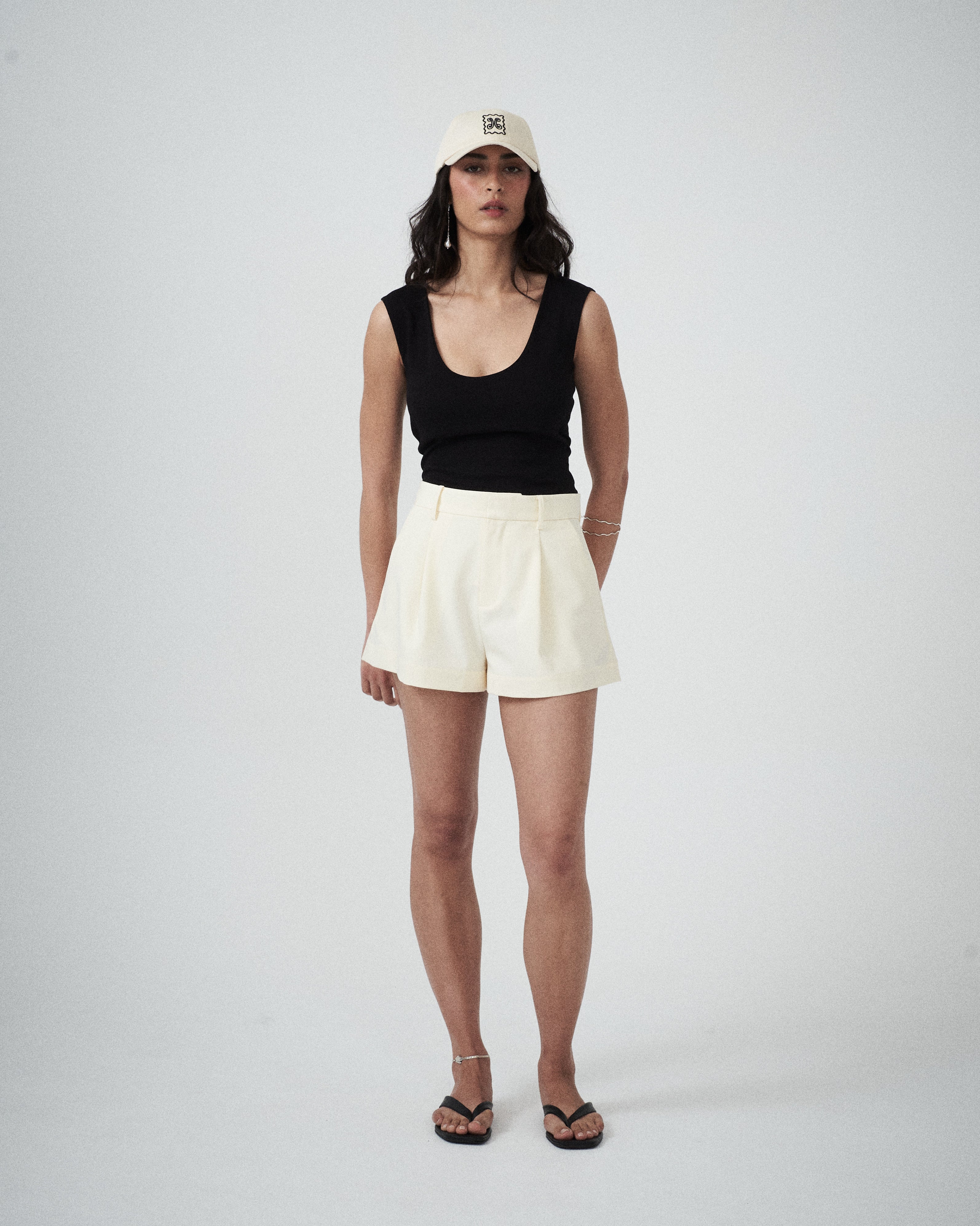 VARNA Valencia Soft Cap styled on model — a cream drill designer cap with embroidered logo.